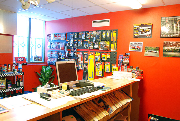 Interiör av Åkes Bil & Motor:s delarbutik — disk, reservdelar och racing-posters på väggarna